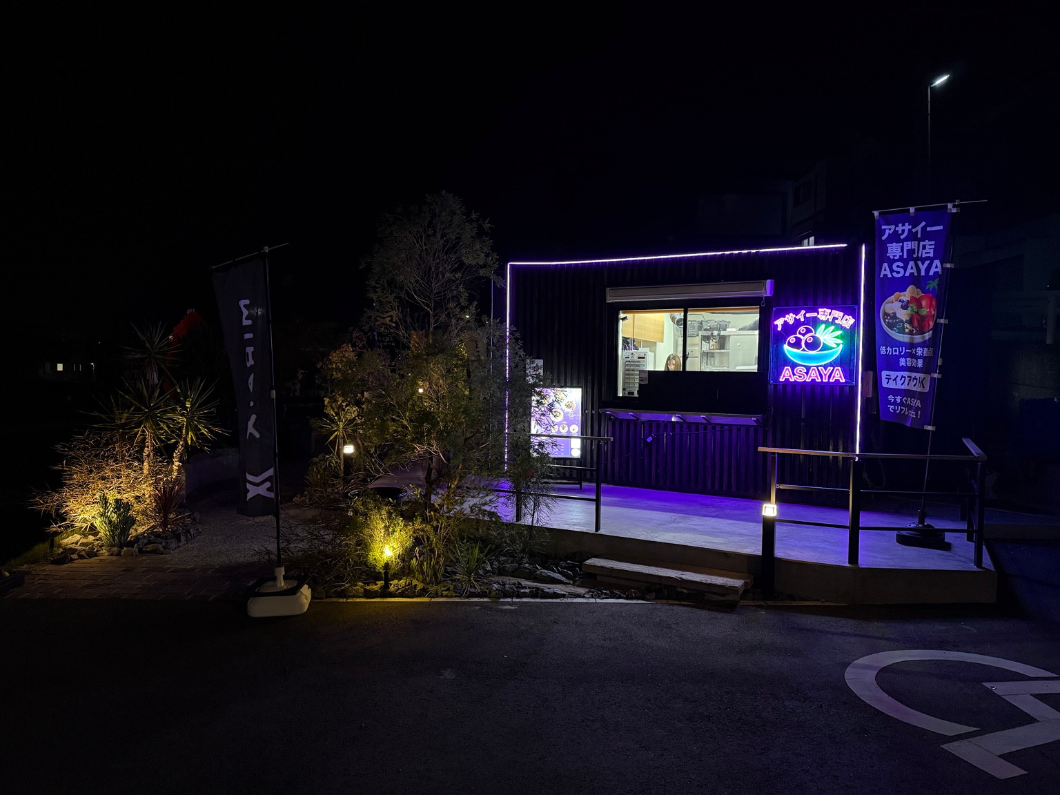 紫のネオンが光るASAYA 香椎本店の夜の店舗外観