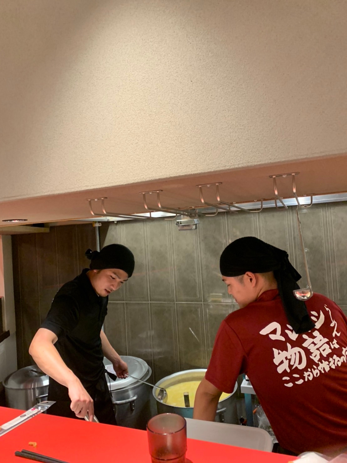 鍋に向かい調理するマシマシ物語の厨房風景